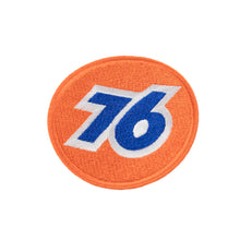 A round orange fabric patch with the blue number 76 in the center.