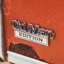 Close-up of a 'Old Man Edition' badge on a red vehicle.