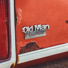 Close-up of a rusted vehicle door with 'Old Man Edition' badge.