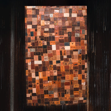 Rectangular rug quilted together using repurposed leather jean tags from many different brand jeans. 