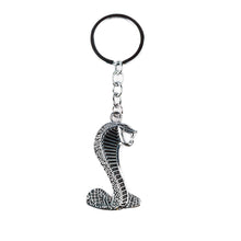 A metal keychain in the shape of a cobra with a black loop at the top.