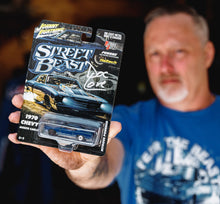 Doc Love holding a 1/64th scale diecast model of a 1970 Chevy Monte Carlo, known as the Street Beast 
